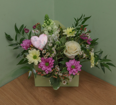 A Floral note - The Floral Note is a kraft envelope with lined plastic inner was filled with floral foam. The design is carefully made by our team of expert florists using traditional shaded pastel flowers. A novelty pick and fabric bow were used to enchant the design.